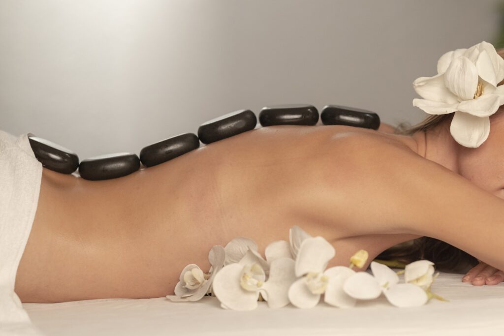 Woman getting a hot stone massage at spa salon
